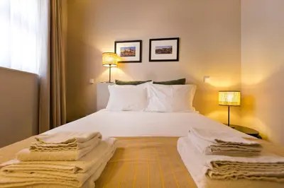 a bedroom with a white bed with towels on it at RVA - Sao Joao Novo Apartments in Porto