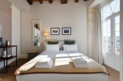a bedroom with a large bed and a large window at RVA - Sao Joao Novo Apartments in Porto