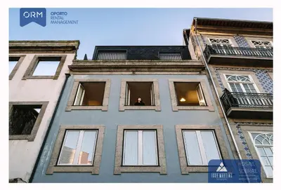 a building with a man looking out of the window at ORM - Cativo Apartments in Porto