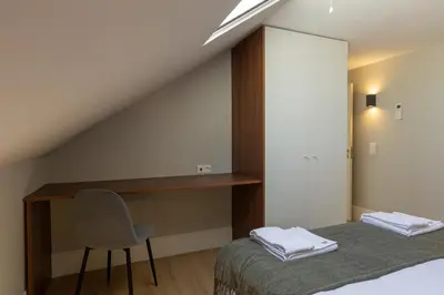 a bedroom with a bed and a desk and a chair at ORM - Bolhao Apartments in Porto