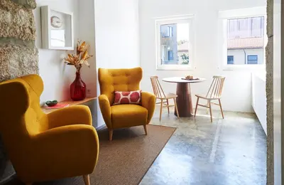 a living room with yellow chairs and a table at Pause Apartments in Porto