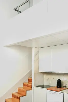 a kitchen with white cabinets and wooden stairs at Lovely Mezzanine in Porto with FREE PARKING in Porto