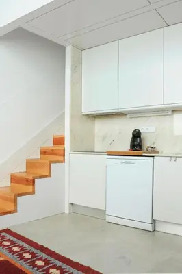 a kitchen with white cabinets and a staircase at Lovely Mezzanine in Porto with FREE PARKING in Porto