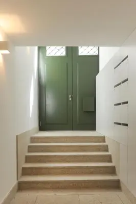 a hallway with a green door and stairs at Lovely Mezzanine in Porto with FREE PARKING in Porto