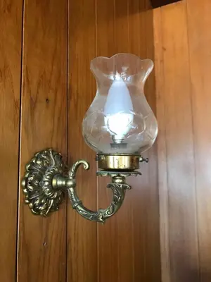 a light on a wooden wall with a glass jar on it at A Casa das Margaridas in Porto