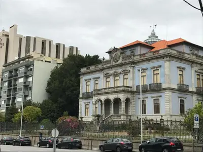 a building with a clock on the top of it at A Casa das Margaridas in Porto