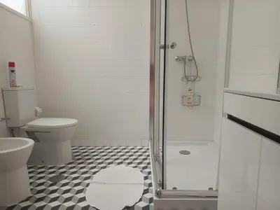 a white bathroom with a toilet and a shower at Combatentes Apartment in Porto