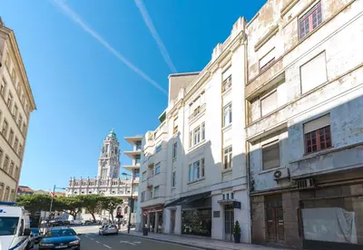 a building on a city street with a clock tower at Deco Gem Aliados in Porto