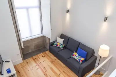 a living room with a gray couch with two pillows at Porto City Center 2 in Porto