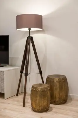 a tripod table lamp with two drums next to it at BRA.com Apartments Oporto Campanhã in Porto