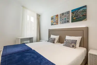 a bedroom with two beds and a window at BRA.com Apartments Oporto Campanhã in Porto