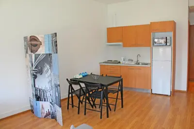 a small kitchen with a table and a refrigerator at Trindade Oporto Apartments Group in Porto