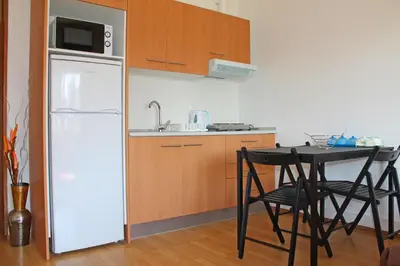 a kitchen with a white refrigerator and a table with chairs at Trindade Oporto Apartments Group in Porto