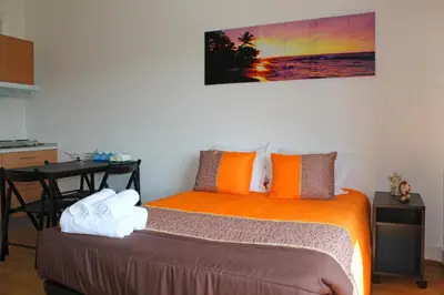 a bedroom with a bed with orange pillows and a table at Trindade Oporto Apartments Group in Porto