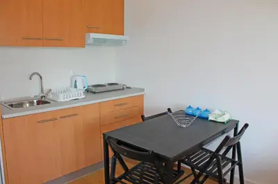 a kitchen with a table with chairs and a sink at Trindade Oporto Apartments Group in Porto