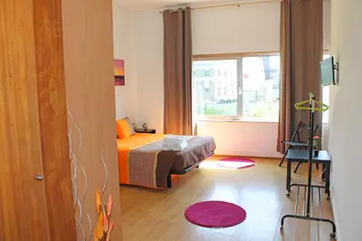 a small bedroom with a bed and a window at Trindade Oporto Apartments Group in Porto