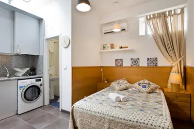 a bedroom with a bed and a washing machine at Host Wise - Cozy Quiet Flat - Trindade Station in Porto