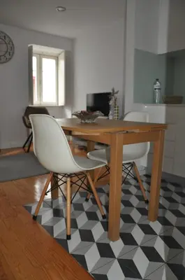 a dining room table with two white chairs and a black and white floor at KOKAS Apartments in Porto