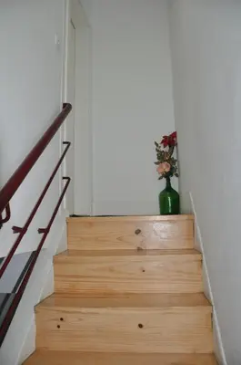 a green vase with flowers sitting on the stairs at KOKAS Apartments in Porto