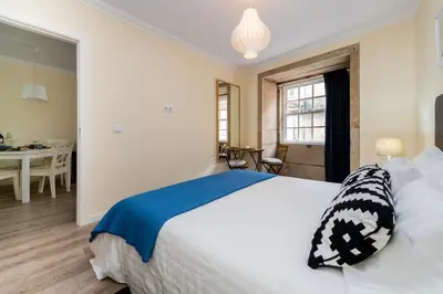 a bedroom with a large bed and a dining room at Merc Porto Ribeira's View in Porto
