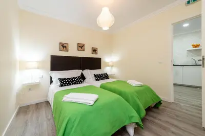 a bedroom with a green bed with two towels on it at Merc Porto Ribeira's View in Porto
