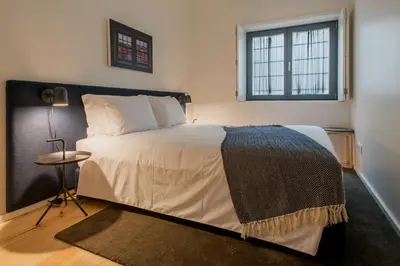 a bedroom with a large bed and a window at Oporto Serviced Apartments - Alvares Cabral in Porto