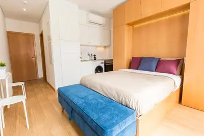 a bedroom with a large bed with a blue bench at Porto 271 Mouzinho Apartamentos in Porto