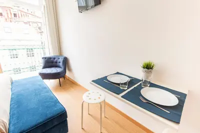 a living room with a table and a blue couch at Porto 271 Mouzinho Apartamentos in Porto