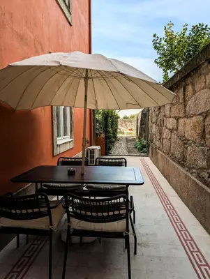 a kitchen with white cabinets and a sink and a table at Liiiving in Porto | Central Garden Flat in Porto