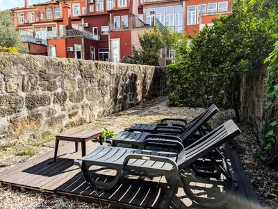 a group of chairs and a picnic table in front of a building at Liiiving in Porto | Central Garden Flat in Porto