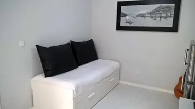 a room with a white couch with black pillows on it at Covelo Apartment in Porto