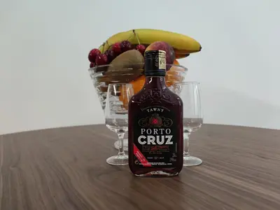 a bottle of porto crunch with a basket of fruit at Suite na baixa do Porto in Porto