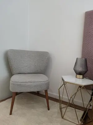a gray chair sitting next to a side table at Suite na baixa do Porto in Porto