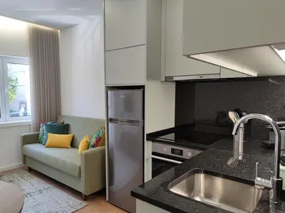 a kitchen with a sink and a couch in a room at Suite na baixa do Porto in Porto