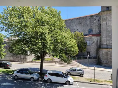 two cars parked in a parking lot next to a tree at Suite na baixa do Porto in Porto