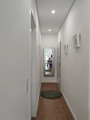 a hallway with white walls and a mirror at Suite na baixa do Porto in Porto