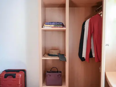 a walk in closet with a suitcase and clothes at ibis Porto Centro São Bento in Porto