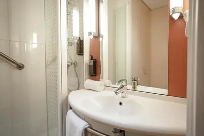 a hotel room with a bed with a hat on it at ibis Porto Centro São Bento in Porto