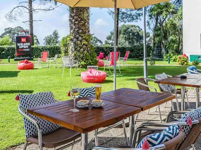 a table with a sandwich and a pizza and glasses of wine at Hotel ibis Porto Gaia in Vila Nova de Gaia
