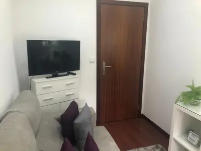 a living room with a couch and a flat screen tv at Alojamento Requinte in Porto