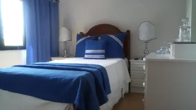 a blue and white bedroom with a bed and a dresser at Alojamento Requinte in Porto