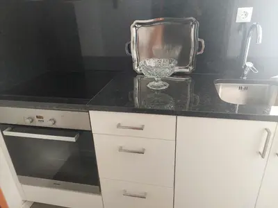 a kitchen with a black counter top with a sink at Alojamento Requinte in Porto