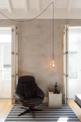 a leather chair sitting on a rug in a living room at Gold & Grey Loft Almada in Porto