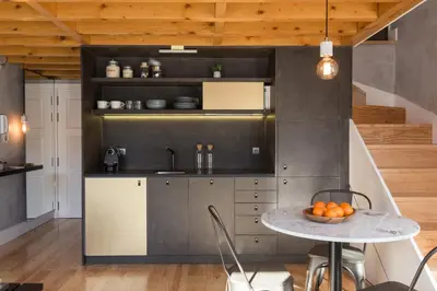 a kitchen with a table with a bowl of oranges on it at Gold & Grey Loft Almada in Porto