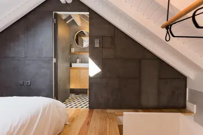 a bedroom with a white bed and a staircase at Gold & Grey Loft Almada in Porto