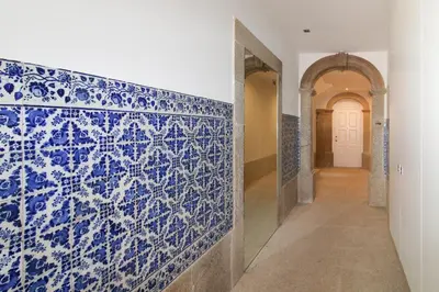 a hallway with a blue and white tile wall at Msc Flats in Porto