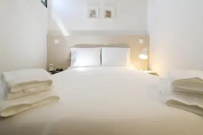a bedroom with a white bed with towels on it at Msc Flats in Porto