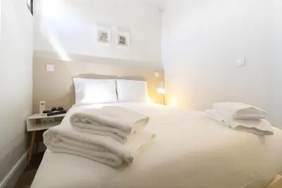 a white bedroom with a bed with white towels on it at Msc Flats in Porto