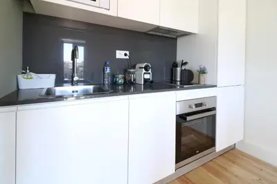 a kitchen with white cabinets and a sink at Msc Flats in Porto