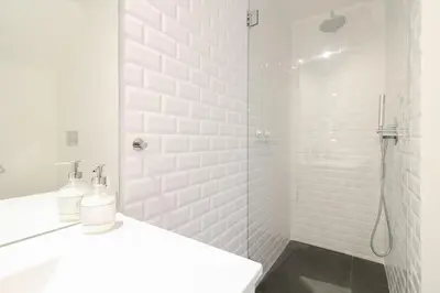 a white bathroom with a shower and a sink at Msc Flats in Porto